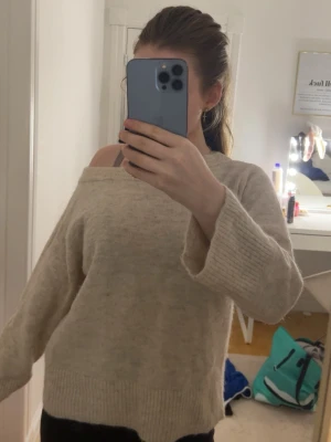 Beige stickad offshoulder-tröja Gina Tricot - Mysig beige stickad tröja från Gina Tricot i storlek 158/164. Tröjan har offshoulder-modell, bred ribbad kant nertill och vid ärmslut. Perfekt för höst och vinter när man vill vara både bekväm och snygg.