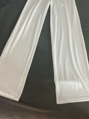 Vita vida oanvända byxor från Nelly - Säljer ett par vita, vida byxor från Nelly med dragsko i midjan. Dom är helt oanvända med prislappen på då jag inte hann att lämna tillbaka dom. Byxorna är tunna och har en avslappnad passform, perfekta för chill dagar eller sommarhäng. Materialet känns mjukt och luftigt. Skriv för fler och bättre bilder🥰❤️