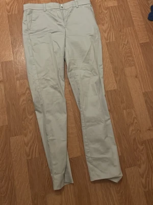 Ljus blåa kostym byxor raka  - Snygga ljus blåa kostym byxor  med klassisk rak passform och bälteshällor. Byxorna har framfickor och diskreta bakfickor, perfekta för en clean och stilren look. Materialet känns mjukt. 