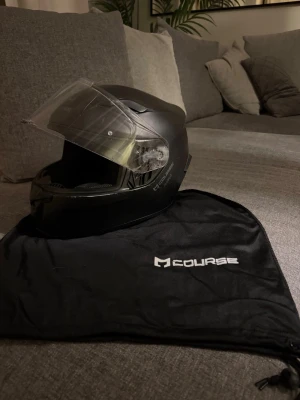 Course surfer MC/ Moped hjälm - Säljer en Course Surfer MC-hjälm i storlek L (59–60 cm). En bekväm och praktisk hjälm med klart visir som ger bra vindskydd. Hjälmen sitter stabilt på huvudet och är utformad för god ventilation och komfort under körning. Repig på utsidan men ingenting som påverkar säkerheten/ användningen av hjälmen😁  Självklart är hjälmen lagligt godkänd och E/E1-märkt, redo att användas i trafik.  ✔ Klart visir ✔ Storlek L – 59/60 cm ✔ E/E1-märkt  ✔ Lätt & bekväm ✔ Stilren design  ✔ Orginal tygpåse medkommer