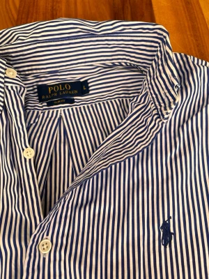 Randig skjorta från ralph lauren - Skjorta i storlek S, marinblå och vit färg. Knapp missas. Kom gärna med bud