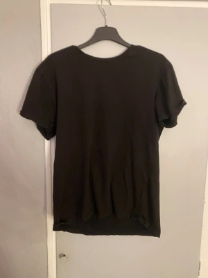 Svart basic t-shirt - En enkel svart t-shirt med rund hals och korta ärmar. Perfekt för att matcha med jeans eller shorts. T-shirten har en rak passform och är tillverkad i mjukt bomullsmaterial som känns skönt mot huden.