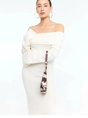 Vit offshoulder långklänning - Snygg vit långklänning med offshoulder-design och långa ärmar. Klänningen har en elegant och stilren look med bred krage och figurnära passform. Perfekt för dig som vill sticka ut med en modern och trendig stil.