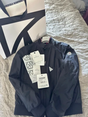 Windbreaker från Moncler - ⭐️Snygg svart vindjacka från Moncler perfekt inför våren                                                                                          ⭐️Strl 2/M knappast använt alla tags och kvitto följer med. Köpt ifrån NK i Stockholm i somras.                 ⭐️ Bara skriva om du har några frågor 