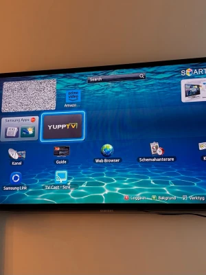 Smart-TV från Samsung, svart - Säljer en svart Smart-TV från Samsung med tunn ram och väggmontering. TV:n har appar som Prime Video, YuppTV och webbläsare, samt flera smarta funktioner. Perfekt för streaming och surf direkt på TV:n. Styr med fjärrkontroll och koppla enkelt till andra enheter.