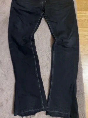 Svarta bootcut jeans från Levi's - Snygga svarta bootcut jeans från Levi's med klassisk femficksdesign och tydliga kontrastsömmar. Jeansen har en liten röd Levi's-tag på bakfickan och är tillverkade i kraftig denim. Perfekta för dig som gillar en tidlös och avslappnad stil.