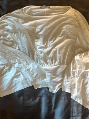 Vit blus med vida ärmar från 157 - Snygg vit blus från 157 med rund halsringning och vida, långa ärmar. Blusen har en markerad midja och är tillverkad i ett mjukt, lätt material som ger en avslappnad men trendig look. Pris går prata om 