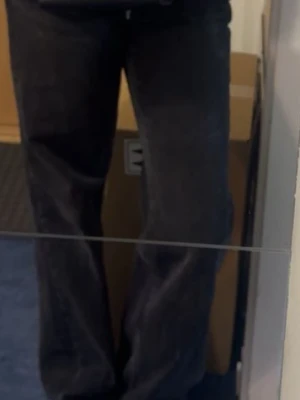 Svarta raka jeans - Säljer ett par svarta jeans med rak passform och klassisk femficksdesign. Jeansen har en tidlös look och är perfekta för dig som gillar en enkel och stilren stil. Materialet är denim och färgen är djupsvart.