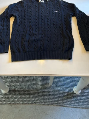 Mörkblå kabelstickad tröja GANT - Säljer en mörkblå kabelstickad tröja från GANT. Perfekt för sommarkvällar!