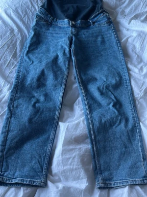 Gravidbyxor  - Säljer ett par klassiska blå jeans med rak passform och hög midja. Fina och sköna gravidbyxor 