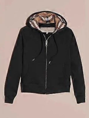 Svart hoodie med Burberry-mönstrad huva - Säljer en svart zip-hoodie från Burberry med klassiskt rutmönster i huvan. Hoodien har dragsko i huvan, fickor framtill och ribbade muddar. Perfekt för dig som vill ha en stilren men ändå lyxig look. Priset kan absolut diskuteres. Skriv för mer bilder!!