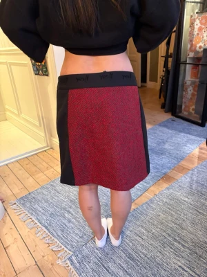 NY röd och svart kjol från Desigual - Snygg kortkjol från Desigual i rött och svart. Kjolen har bred resår i midjan med logga, svarta sidor och en röd mönstrad panel framtill och bak. Ny med lappar kvar.