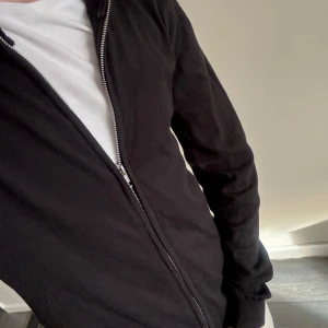 Svart fullzip  - Säljer en lite tunnare svart ziptröja från Matinique med ståkrage och ribbade muddar. Tröjan är tillverkad i mjukt stickat material och har en enkel, stilren design som passar perfekt till jeans eller chinos. Använd fåtal gånger