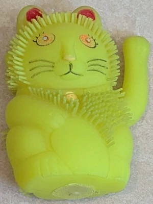Gul  kattfigur - Rolig gul kattfigur i mjukt gummimaterial med piggar runt huvudet och magen. Katten har röda öron, tecknade ögon och en uppsträckt tass. Perfekt som stressleksak eller dekoration.