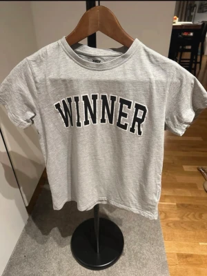 T-shirt storlek 150 - Grå T-shirt med tryck på framsidan.