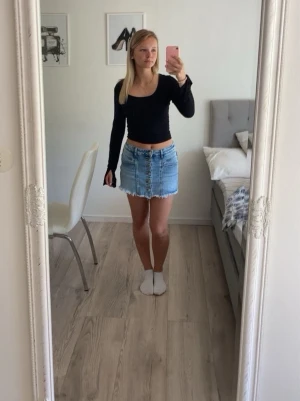 Ljusblå jeanskjol/shorts från Folyrose - Säljer en ljusblå jeanskjol/shorts från Folyrose med råa, fransiga kanter och knappar framtill. Kjolen har fickor både fram och bak samt bälteshällor. Perfekt för dig som gillar en avslappnad och trendig denimlook. Det är shorts under kjolen så när du har den på dig och men ser dig bakifrån så ser det ut som shorts. Säljer den då den är för liten❣️