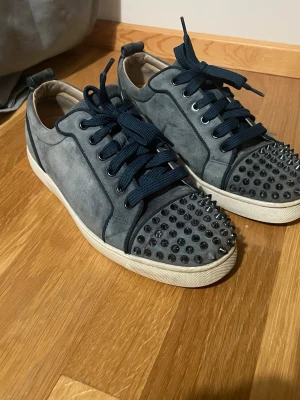 Ljusblåa Loubs Med Spikar - Säljer mina äkta ljusblåa Christian Louboutin med spikar i bra skick. Skorna är riktigt snygga och drar mycket uppmärksamhet, perfekta om du vill sticka ut, även med tanke på att sommaren är runt hörnet!  Använda varsamt och fortfarande i fint skick. Stor efterfrågan på denna modell och denna färg blandning hittar man inte ofta.  Pris ej hugget i sten vid snabb och smidig affär. Inga dumma bud eller dumma frågor.  Kartong och tillbehör medföljer ej.