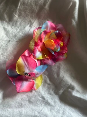 2 st Flerfärgad blomformad hårklämma - Snygg hårklämma i form av en stor blomma med färgglada blad i rosa, gult, blått och orange. Tillverkad i tunt tygmaterial som ger en lätt och luftig känsla. Perfekt för att ge frisyren en färgklick och unik stil.