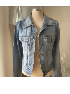 Klassisk ljusblå jeansjacka S - Snygg ljusblå jeansjacka i klassisk modell med krage, bröstfickor med lock och knappar framtill. Jackan har långa ärmar och är tillverkad i denim. Perfekt för en avslappnad och trendig look.
