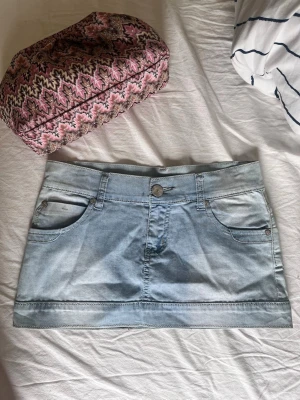 vintage Ljusblå jeanskjol  - Snygg ljusblå jeanskjol i kort modell med klassiska fickor fram och bak samt bälteshällor. Kjolen har en knapp och dragkedja framtill 💗💗✨ helt ny