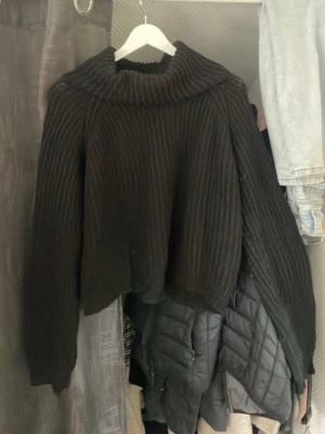 Svart ribbstickad polotröja - Säljer en svart ribbstickad polotröja med oversized passform och långa ärmar. Tröjan har en bred polokrage och är tillverkad i ett mjukt, tjockare material som passar perfekt när det är kallt ute.