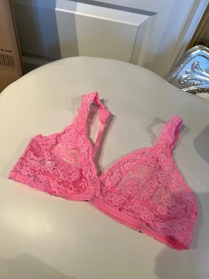 Rosa spets-bh från Sloggi - Söt och bekväm rosa bh från Sloggi i mjuk spets. Bralett-modell utan bygel med breda axelband och fina spetsdetaljer. Perfekt för dig som gillar en feminin och avslappnad stil.