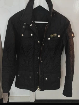 Svart quiltad jacka från Barbour - Snygg svart quiltad jacka från Barbour i fint skick men saknar tyvärr skärpet som jag inte lyckats hitta så därav priset! Inköpt för 2500 kr 