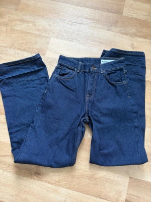 Mörkblå raka jeans från Bershka - Säljer ett par mörkblå jeans med rak passform och klassiska bakfickor. Jeansen har bälteshällor och kontrastsömmar. Perfekta till vardagsstilen och tillverkade i ett mjukt denimtyg.