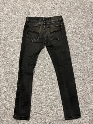 Svarta jeans från Nudie Jeans - Säljer ett par svarta jeans från Nudie Jeans. Dem har snygga tvätt fläckar och är riktigt feta, perfekt till våren. Storlek är W31 och L32