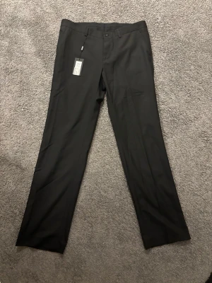 Svarta kostymbyxor från Bertoni - Snygga helt nya svarta kostymbyxor från Bertoni med klassisk rak passform. Byxorna har diskreta fickor och stilrena detaljer, perfekta för en clean look. Prislappen sitter kvar då de aldrig är använda. Skriv gärna vid frågor!😁✅