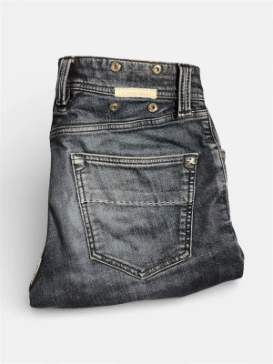 Mörkblå jeans från Tramarossa - Snygga mörkblå jeans från Tramarossa med slitna detaljer och kontrastsömmar. Klassisk femficksmodell med metallknappar och patch baktill. Jeansen har en tvättad look och är tillverkade i denim med en skön känsla.