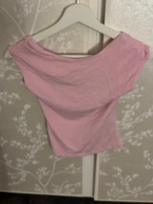 Ljusrosa offshoulder topp - Söt ljusrosa offshoulder topp från Bik Bok. Toppen är ärmlös och har en croppad passform som sitter snyggt på kroppen. Tillverkad i mjuk bomull som känns skön mot huden. Perfekt för dig som vill ha en enkel men trendig topp till sommaren.