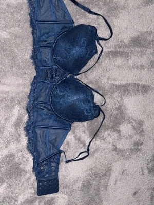 Mörkblå spets-bh med banddetaljer - BH är mycket bra och passar perfekt. Jag har bara använt den en gång. Den har glitter och färgen är perfekt