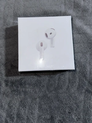 Apple AirPods 4 med brusreducering - Säljer ett par Apple AirPods 4 med aktiv brusreducering. Trådlösa hörlurar med laddningsetui, kompatibla med USB-C. Perfekta för musik, samtal och gaming. Klassisk vit design och smidig förvaring i det medföljande etuiet. Kvitto kan skickas privat och priset kan diskuteras privat