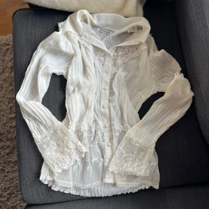 Vintage blus med spetsdetaljer - Säljer en krämvit blus med långärmad design, genomskinligt material och dekorativa knappar! 🤍Jag köpte den i Depart.A.Mental, men använder den inte längre.