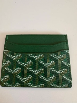 Grön korthållare - Snyggt grön korthållare med det klassiska mönstret i vitt och gröny. Tillverkat i canvas och läder med flera kortfack. Perfekt för dig som vill ha en stilren och exklusiv accessoar i fickan. Pris kan diskuteras vid snabb äffär!✅