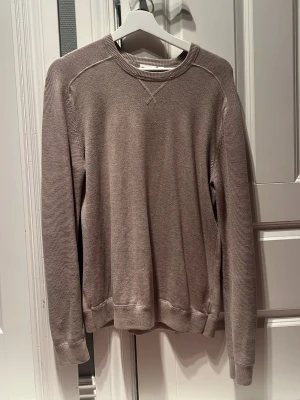 Beige sweatshirt - En enkel och stilren beige sweatshirt med rund halsringning och raglanärmar. Tröjan har ribbade muddar vid ärmslut och nederkant samt diskreta sömdetaljer vid halsen.