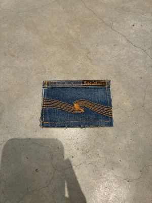 Jeansplånbok - Handsydd plånbok i vintage jeans. Varje exemplar är unikt med snygga detaljer. Plånboken håller flera kort utan att dem åker ut. Små variationer i färg och struktur visar på plaggets tidigare historia💙  Tiktok: Jeanius.bc