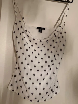 Vit prickig linne från newyorker - Säljer en vit linnetopp från Newyorker med svarta prickar och tunna axelband. Toppen har en lös passform och är i nyskick, storlek S