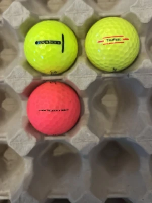 Färgglada golfbollar från Titleist 15kr styck - Tre golfbollar från Titleist i neonfärger, två gula och en rosa. Modellerna inkluderar Tour Soft, TruFeel och Velocity. Bollarna har klassisk dimple-design och tydliga logotyper. Perfekta för dig som vill ha synliga bollar på golfbanan.