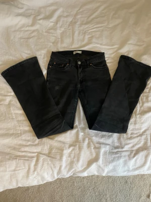 Svarta bootcut jeans med låg midja - Säljer ett par svarta bootcut jeans med låg midja och klassisk femficksmodell. Använd flitligt därav lite slitna, inte urtvättade utan ska vara off black