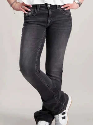 Svarta bootcut jeans med slitning - Snygga svarta bootcut jeans med låg midja. Jeansen har en något utsvängd passform nertill och vita sömmar. Perfekta för dig som gillar en chill men modern look