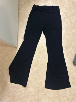 Svarta utsvängda mjukisbyxor - Svarta mjukisbyxor med utsvängda ben och bred midjeresår. Sköna och stretchiga, perfekta för en avslappnad stil. Tillverkade i mjukt material som känns bekvämt hela dagen.