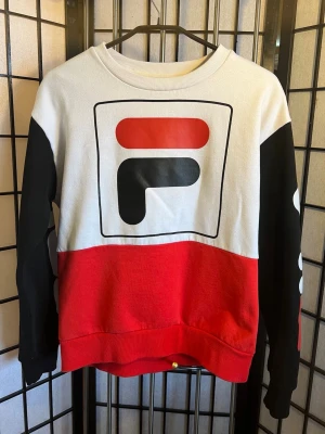 FILA Y2K Colorblock Crewneck – äkta 00s vibe - Riktig main character energy. Vit / röd / svart colorblock med stort F-logo framtill – exakt den där 90s/00s sportcore-looken som är överallt just nu.  Ger direkt: • Y2K • mcbling / sporty spice • 00s it-girl • baggy jeans + sneakers • clean but statement  Sitter boxy och fett snyggt oversized. Funkar unisex.  📏 Storlek: M 📐 Längd: ca 56–57 cm 📐 Bredd (armhåla–armhåla): ca 50–52 cm  Skick: Bra vintage condition. Inga hål. Normal användning.  Perfekt till baggy jeans, adidas samba, campus, air fo