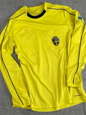 ⚽️ Adidas SvFF Referee Jersey Neon Yellow Climacool L - Official Adidas SvFF Swedish Football Association referee jersey in high-visibility yellow with Climacool fabric. Features chest referee pockets, SvFF crest and Svenska Spel Fair Play sleeve patch. Lightweight breathable match official shirt. Great for referees, football collectors or sporty streetwear.  Size L  Measurements (flat): S2S 56 cm P2P 56 cm Length 70 cm  #adidas #svff #refereejersey #footballreferee #soccerreferee #climacool #footballgear #sportswear #swedishfootball 091