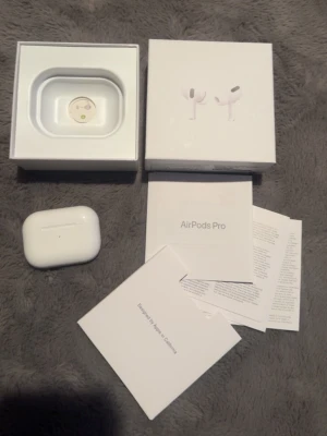 Apple AirPods Pro med MagSafe - Säljer ett par Apple AirPods Pro med MagSafe-laddningsetui. Hörlurarna är vita, trådlösa och har en stilren, kompakt design. Perfekta för dig som vill ha grymt ljud och smidig anslutning till din iPhone eller andra Apple-enheter.