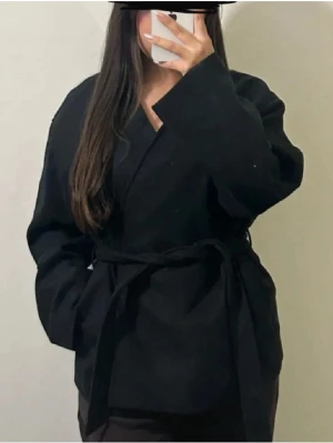 Svart Zina kappa med bälte från Bik Bok (strl S) - Svart Zina kappa från Bik Bok med bälte i midjan och v-ringad hals. Ny med prislapp, original priset 699kr. Skriv om flera bilder önskas 🥰