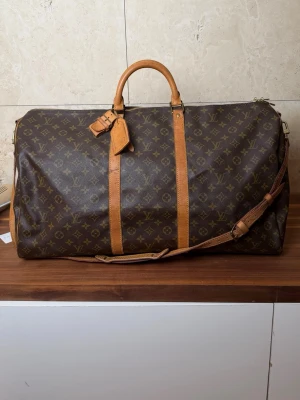 Louis Vuitton Keepall - Lv Keepall bandolier 60 L. Fint vintage skick. Pris 5890 finns att köpa på våran hemsida, Fashionels.com