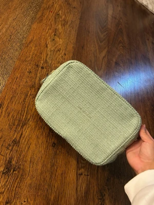 Mintgrön necessär från lyko Lovables - Säljer en mintgrön necessär från lyko Lovables. Väskan är rektangulär och har ett vävt tyg med struktur. Perfekt för att organisera smink eller småprylar. Stängs med dragkedja och har en stilren look.