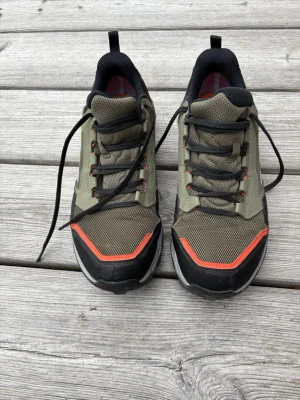Adidas Terrex gröna sneakers / vandringsskor - Snygga Adidas Terrex sneakers i olivgrönt med svarta och orange detaljer. Skorna har mesh- och syntetmaterial för bra andningsförmåga och komfort. Lågt skaft och klassisk snörning. Perfekta för dig som gillar streetwear och outdoor-vibe.